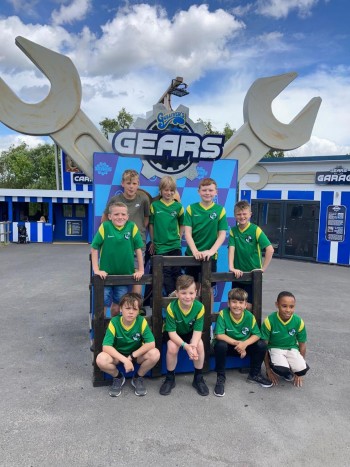 Sports team celebrate during group day out at Gulliver's Theme Parks. Stands on a podium at Gulliver's Gears themed area.